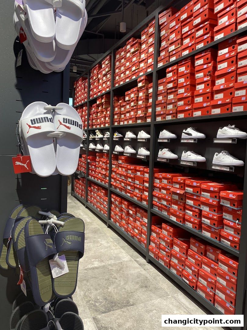 Puma outlet store interior with shelves full of shoe boxes and displayed footwear.