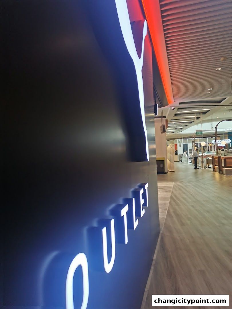 Puma Outlet sign with illuminated letters on a dark wall.