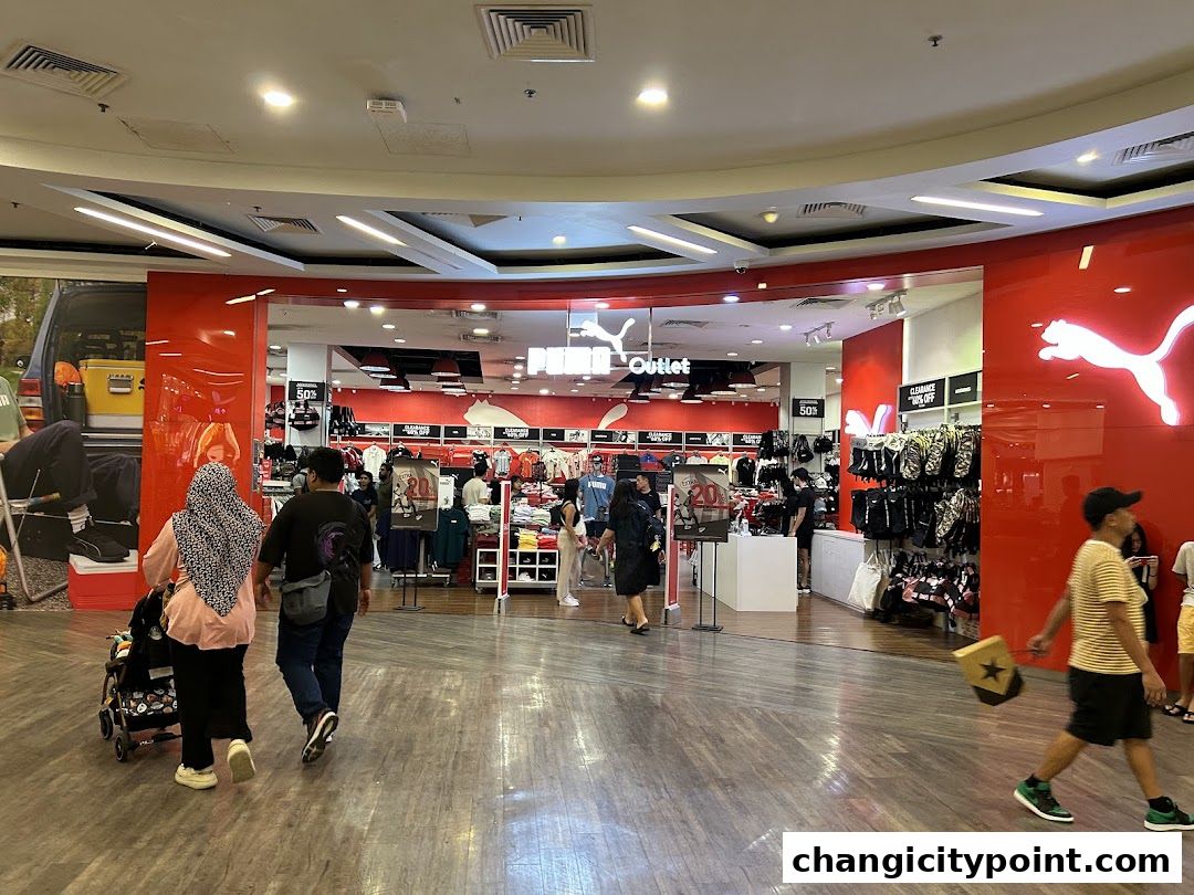 Puma Outlet store entrance with red branding and sportswear displays.