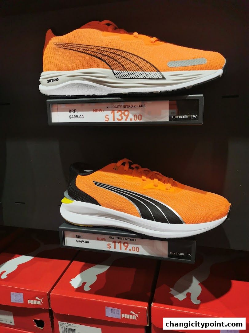 Orange Puma running shoes displayed with price tags and boxes below.
