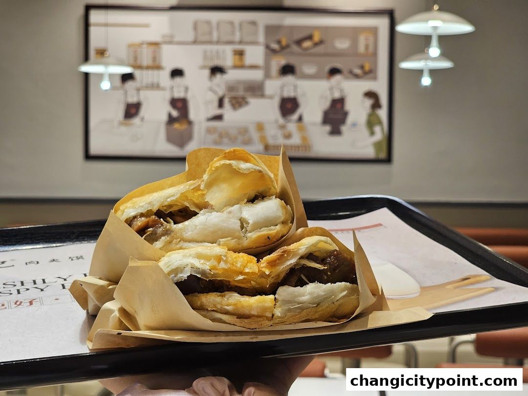 Two Rougamo sandwiches wrapped in paper on a tray, with a stylized illustration in the background.