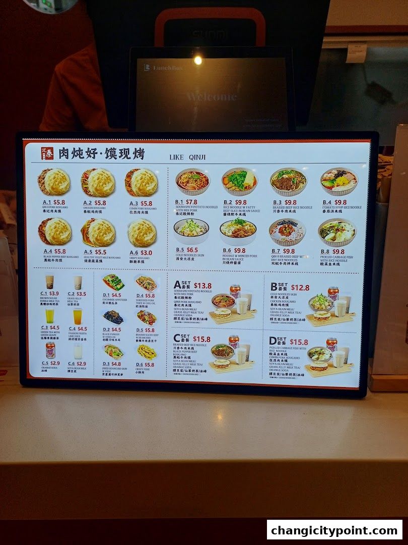 A digital menu board displays various Chinese dishes, drinks, and meal sets with prices.