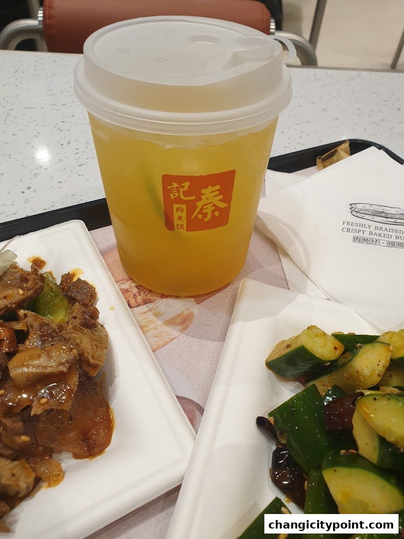 A refreshing beverage and two dishes of food served on a tray.