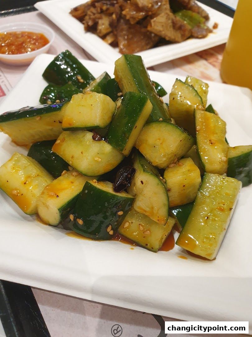 A plate of chopped cucumbers in a savory sauce with sesame seeds.