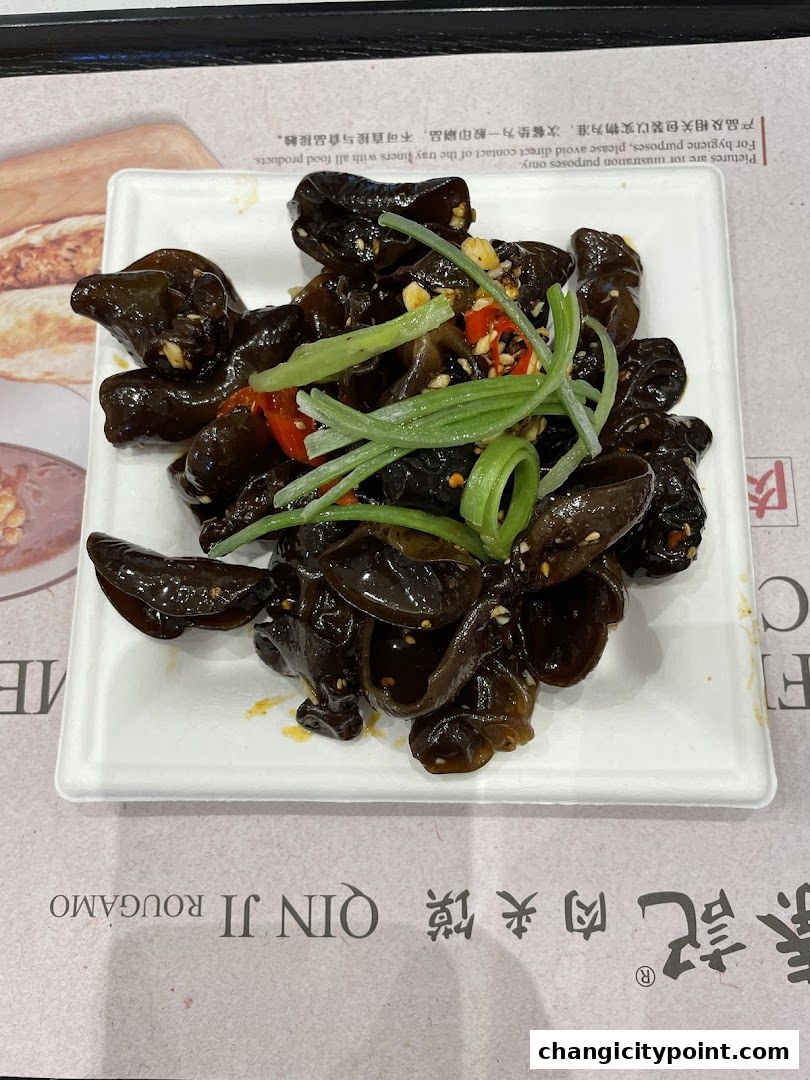 A plate of black fungus salad with scallions and chili peppers.