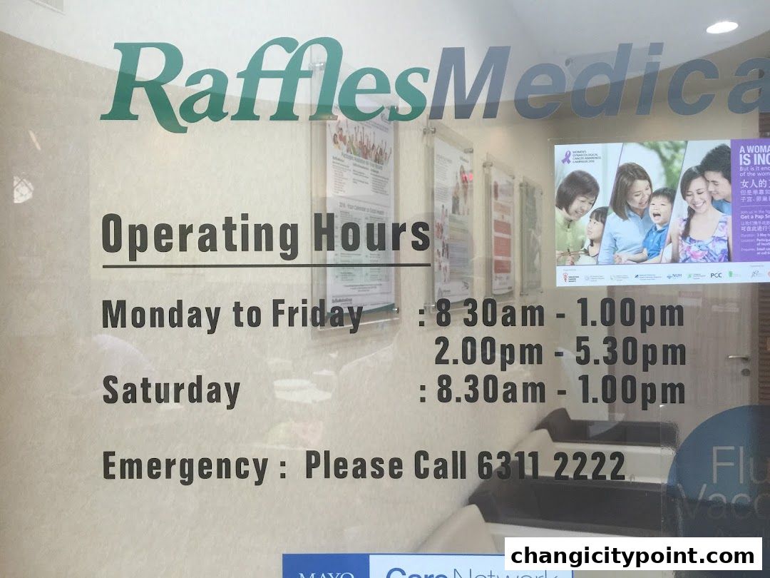 Raffles Medical Changi City Point operating hours and emergency contact information displayed on glass.