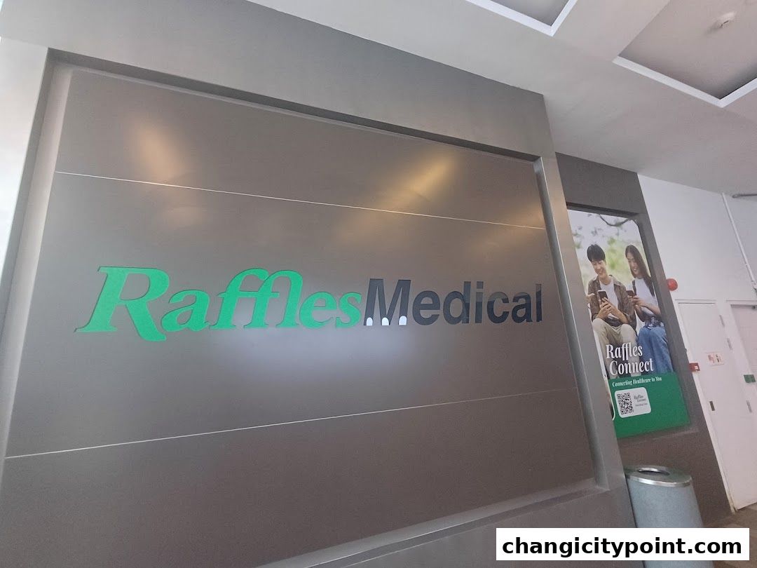 The entrance sign for Raffles Medical Changi City Point with a promotional poster.