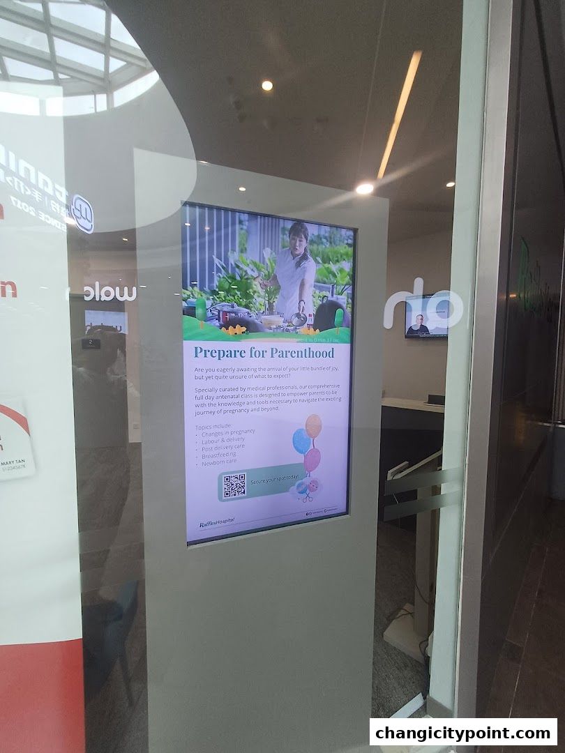 A digital display advertises a 'Prepare for Parenthood' antenatal class by Raffles Hospital.
