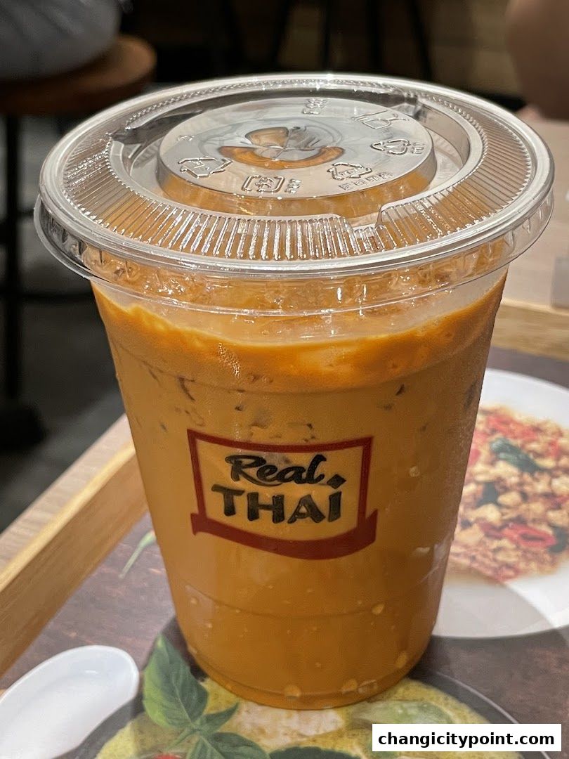 A refreshing Thai iced tea from Real Thai, served in a clear plastic cup.