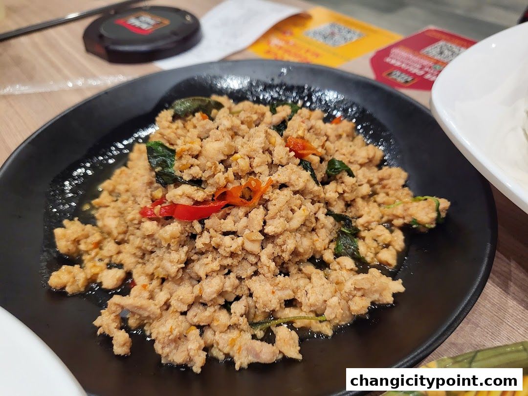 A close-up of a delicious plate of minced meat with basil and chili.