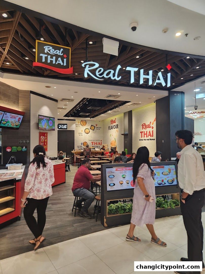 The exterior of a Real Thai restaurant with people walking by and digital menus.