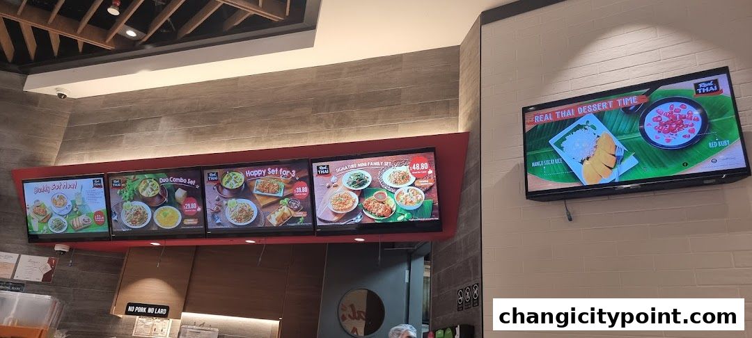 Digital menus display Thai food sets and desserts at Real Thai restaurant.