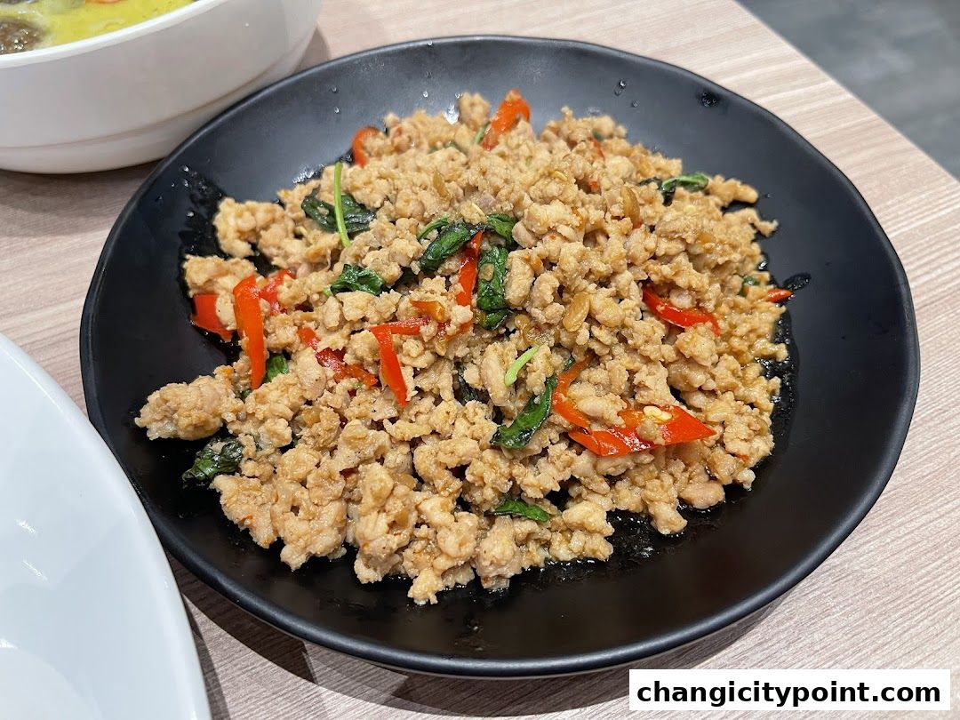A close-up of a plate of minced meat stir-fried with basil and chili.