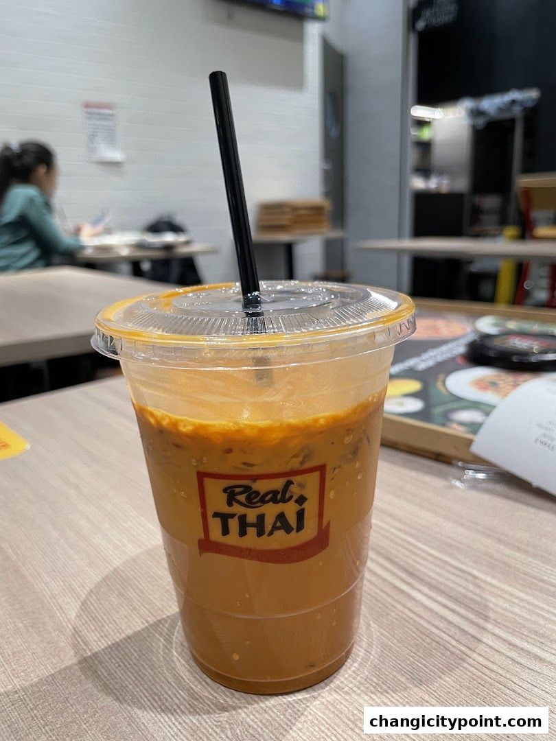A refreshing Thai iced tea from Real Thai, served in a clear plastic cup with a straw.