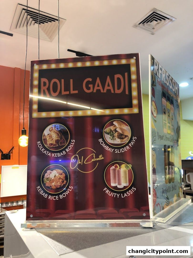 A menu board for Roll Gaadi, showcasing Kolkata Kebab Rolls, Kebab Rice Bowls, Bombay Slider Pavs, and Fruity Lassis.