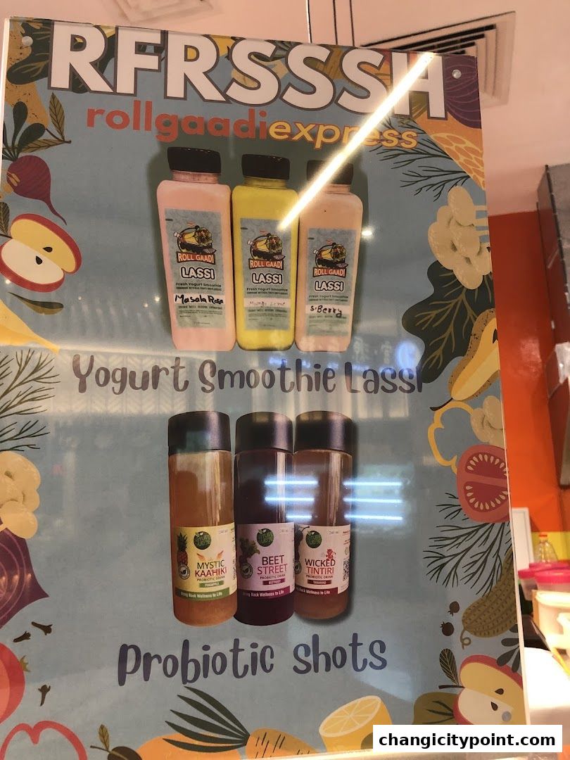 A poster displaying various Lassi flavors and Probiotic shots from RollGaadi Express.