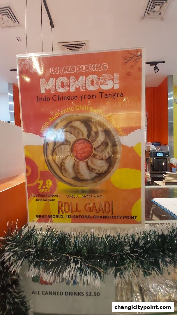 A sign introducing Momos from Roll Gaadi, with pricing and location details.