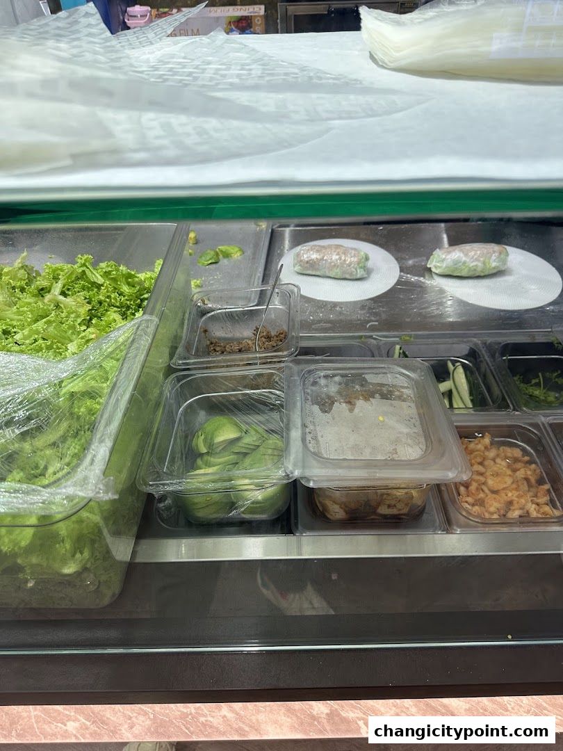 Fresh ingredients and prepared rolls displayed in a refrigerated counter.