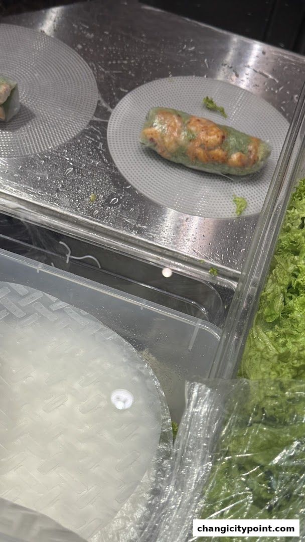 Freshly prepared Vietnamese spring rolls displayed in a chilled food counter.