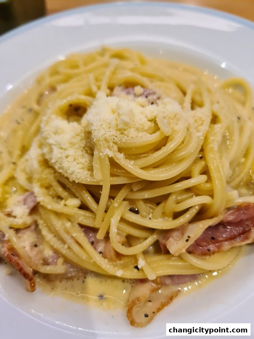 A close-up shot of a delicious spaghetti carbonara dish topped with grated cheese.