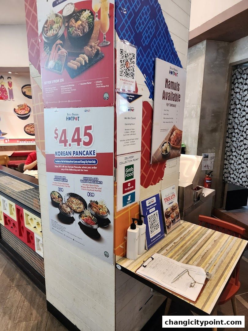 Promotional posters and a table with a menu and order pad at Seoul Garden Hot Pot.