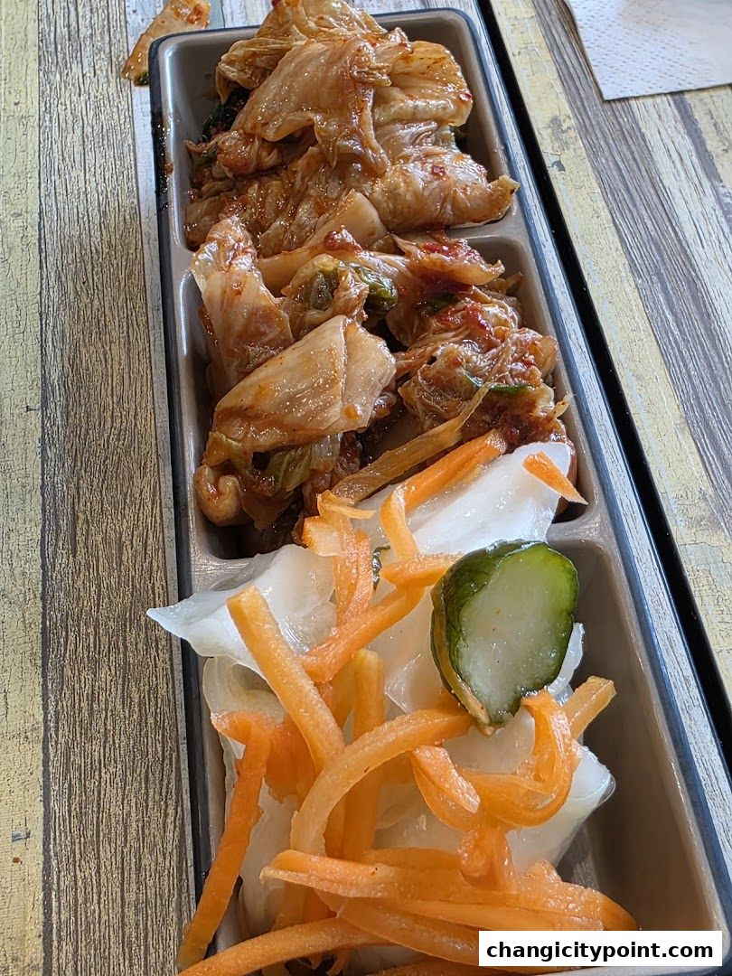 A close-up of a serving tray with kimchi and pickled vegetables.