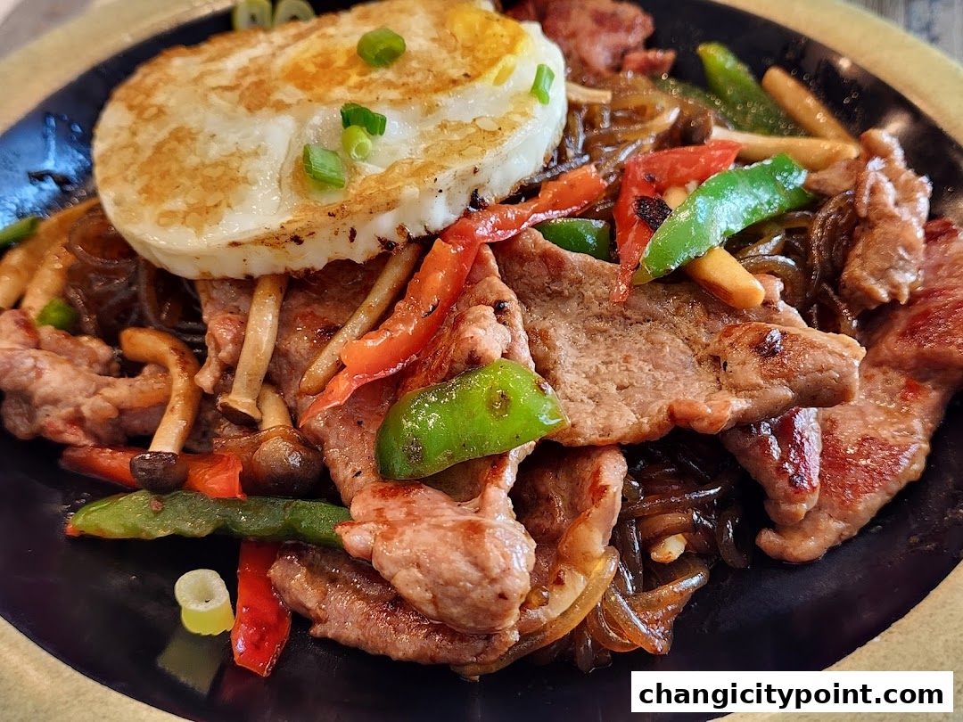 A close-up of a delicious hot pot dish with beef, vegetables, and a fried egg.