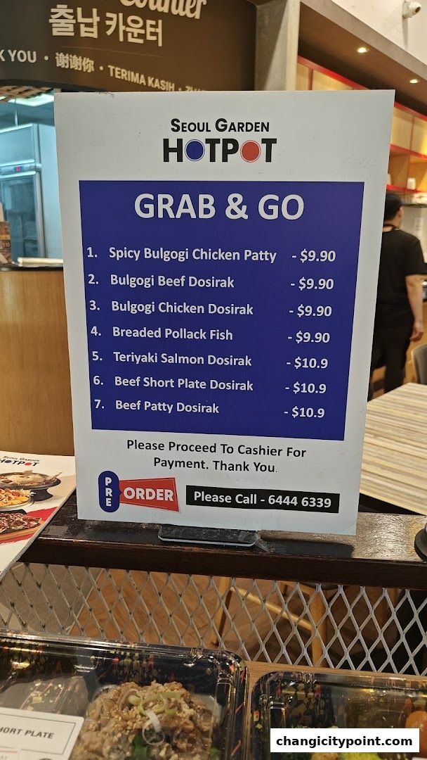 A sign displays Seoul Garden Hotpot's 'Grab & Go' menu with prices.