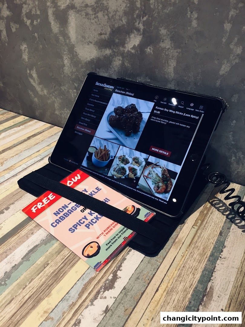A tablet displaying the Seoul Garden Hot Pot menu with Korean dishes and a free pickle promotion.