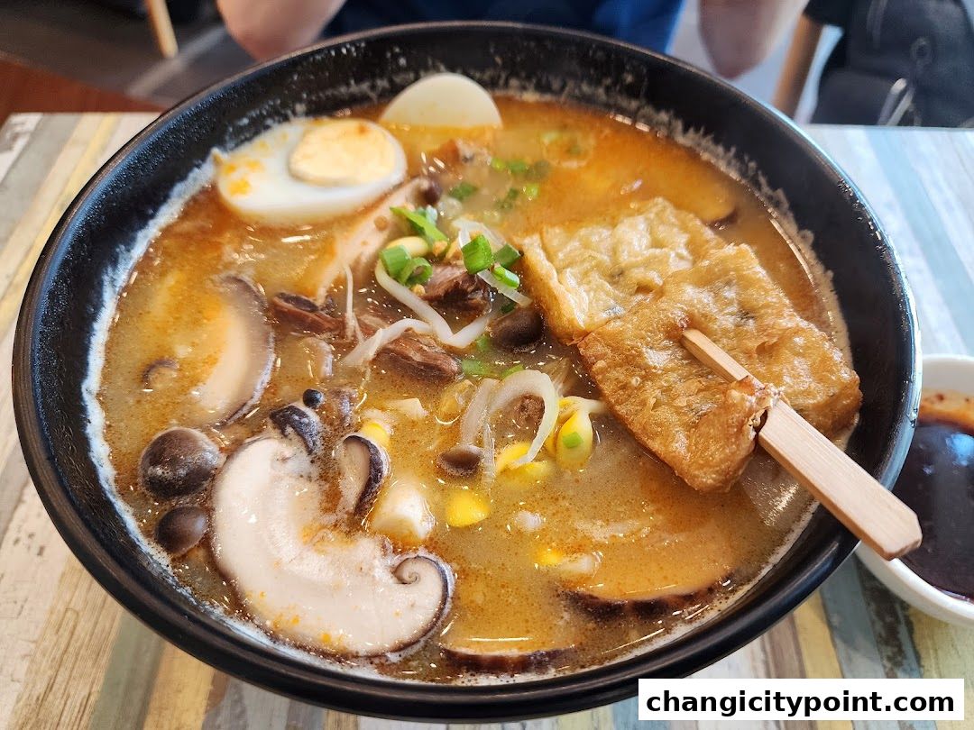 A steaming bowl of hot pot with noodles, egg, mushrooms, and tofu.