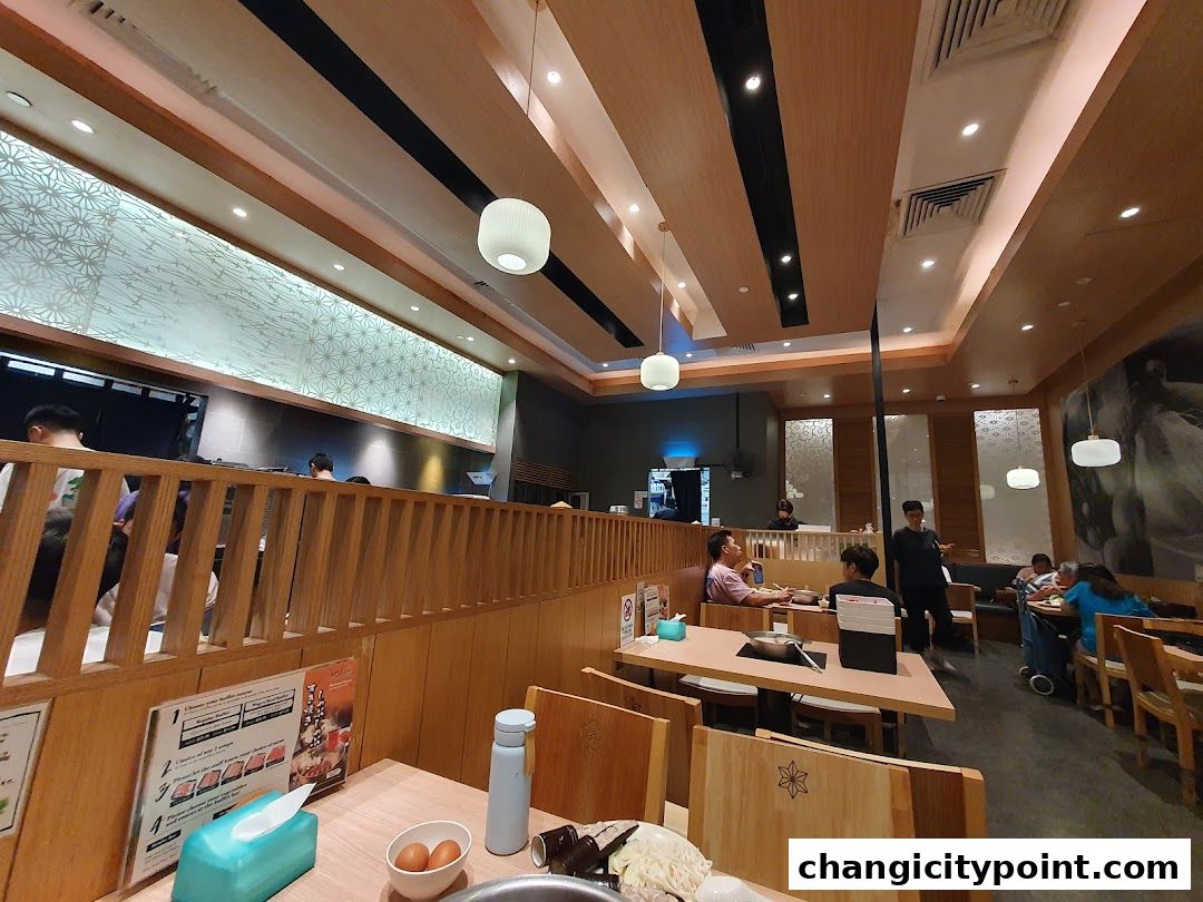 Interior view of a Shabu Sai restaurant with diners and wooden decor.