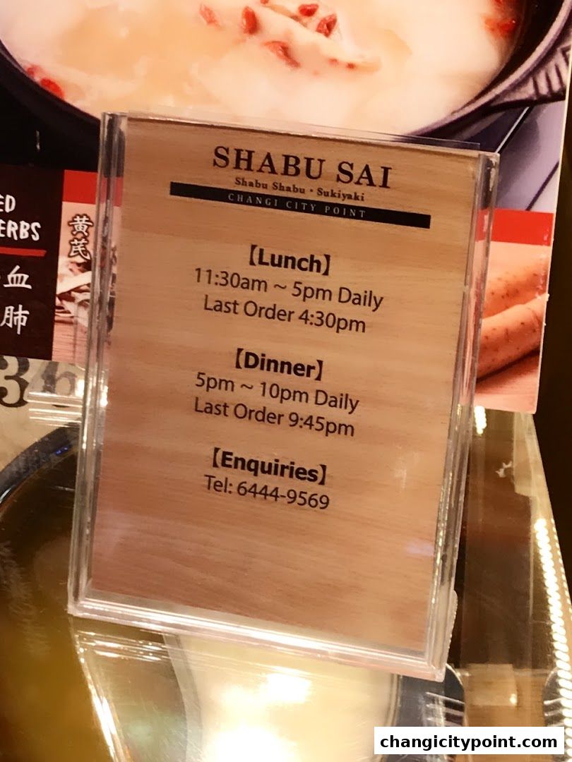 A sign displays operating hours and contact information for Shabu Sai restaurant.