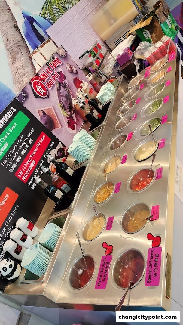 A hot pot restaurant's sauce bar with various dipping sauces and ingredients.