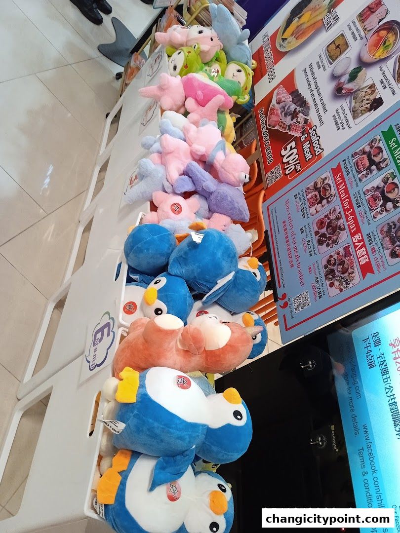 A display of plush toys, including penguins and other animals, in front of a hot pot restaurant menu.