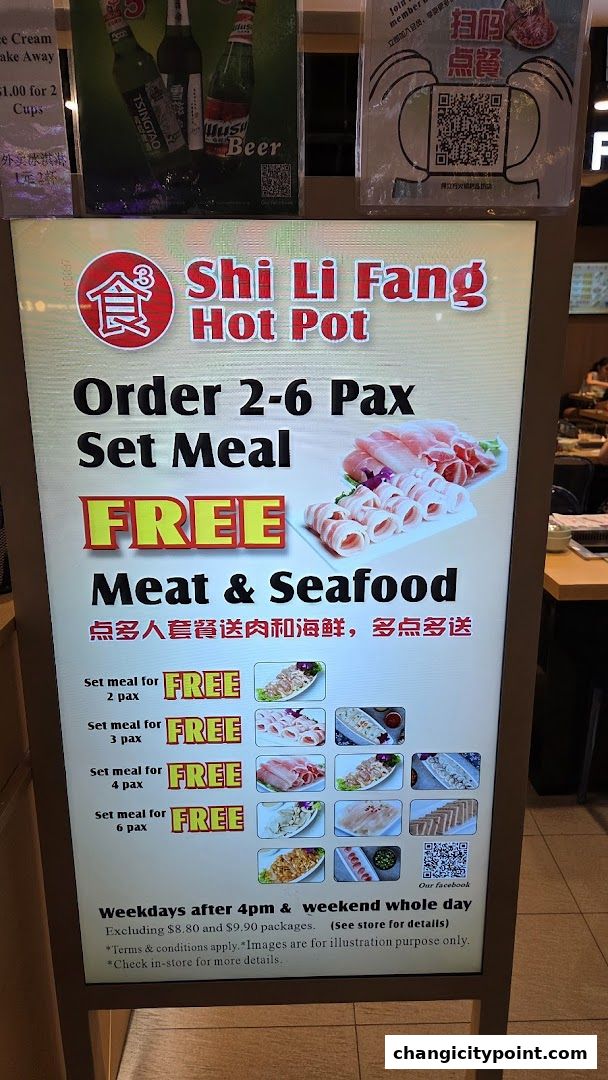 A promotional sign for Shi Li Fang Hot Pot offering free meat and seafood with set meals.