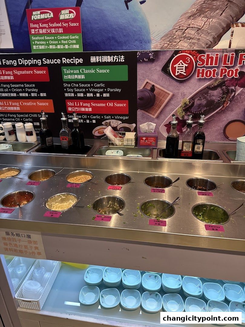 A hot pot restaurant's dipping sauce station with various ingredients and sauces.