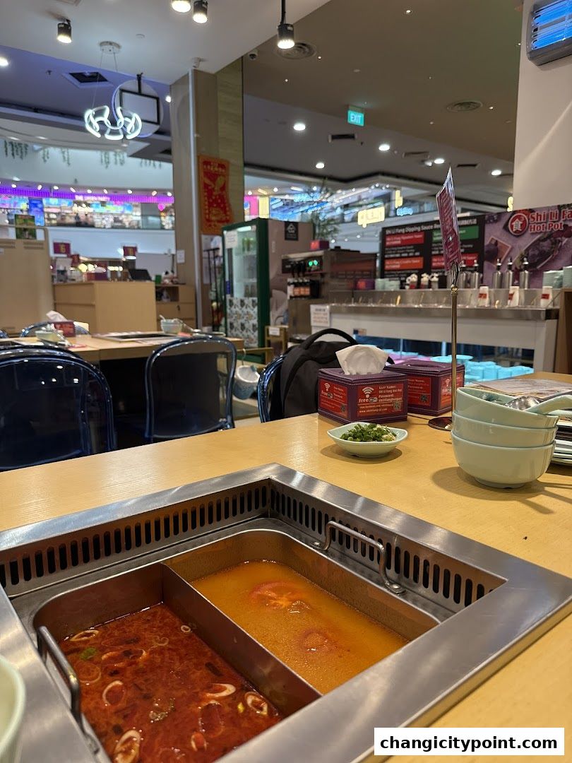 A hot pot with two broths sits on a table at Shi Li Fang Hot Pot.