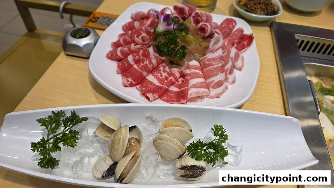 A plate of thinly sliced beef and a dish of clams on ice, ready for hot pot.