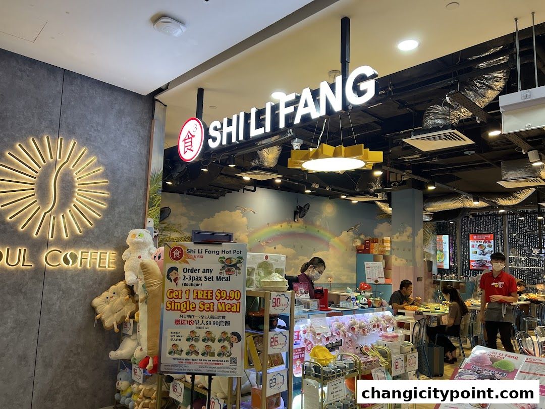 The entrance of Shi Li Fang Hot Pot restaurant with promotional posters and plush toys.