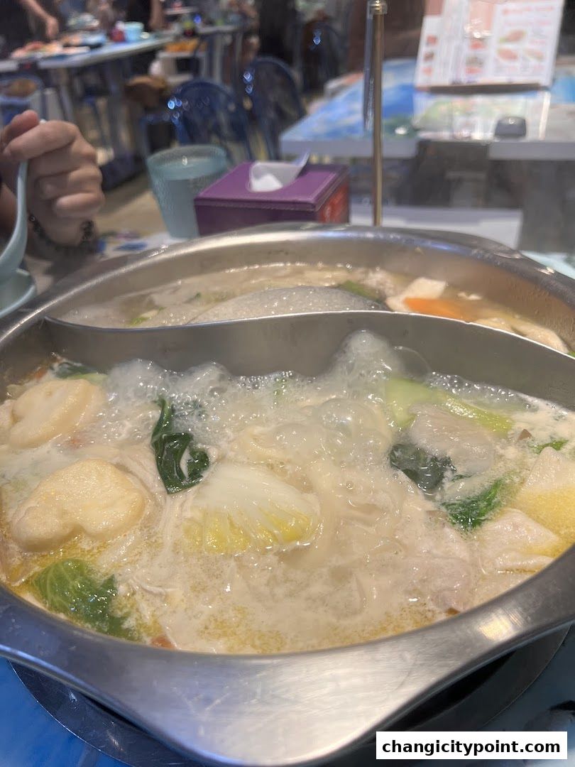 A bubbling hot pot filled with vegetables and dumplings, ready to be enjoyed.
