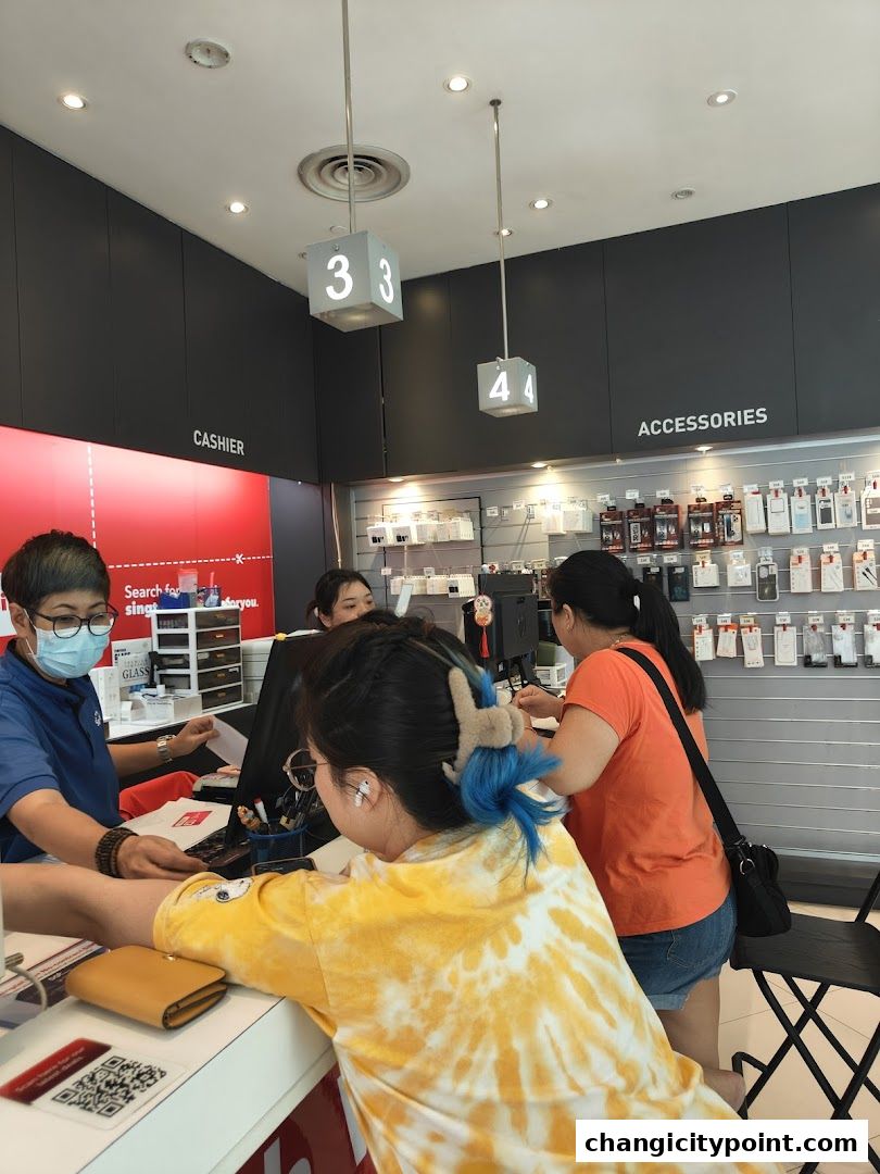 Customers interacting with staff at a Singtel Exclusive Retailer counter.