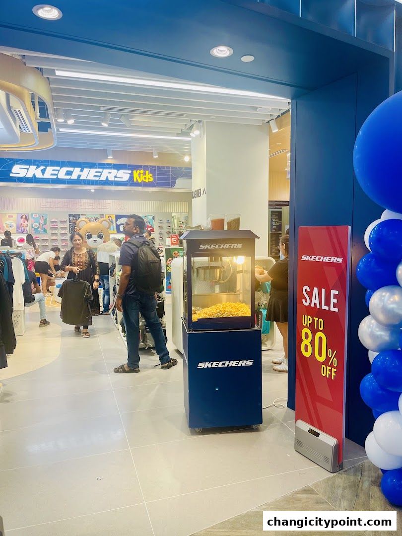 Entrance to Skechers Outlet Changi City Point with a sale banner and popcorn machine.