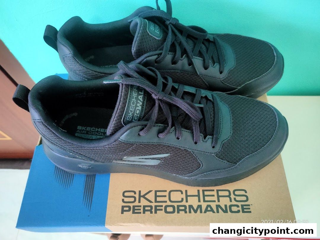 A pair of black Skechers GOwalk shoes displayed on their box.