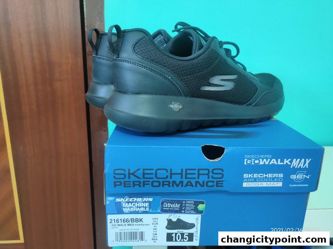 A pair of black Skechers Go Walk Max shoes displayed on their blue box.