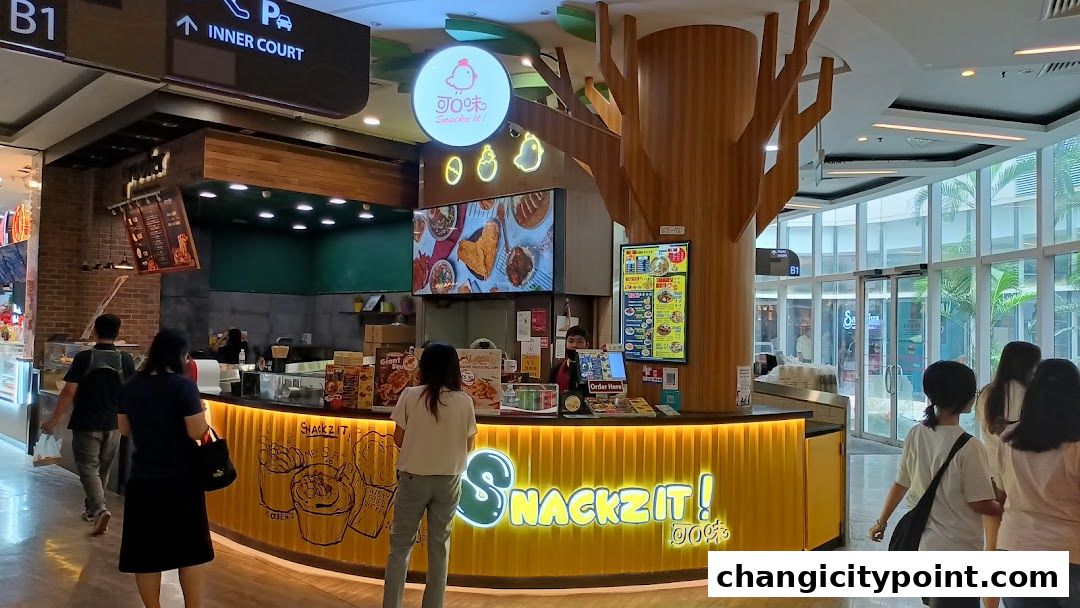 A bright and inviting Snackz It! shop with a prominent yellow counter and menu displays.