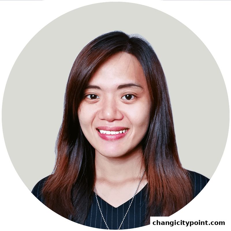 A smiling woman with long, dark hair and a necklace.