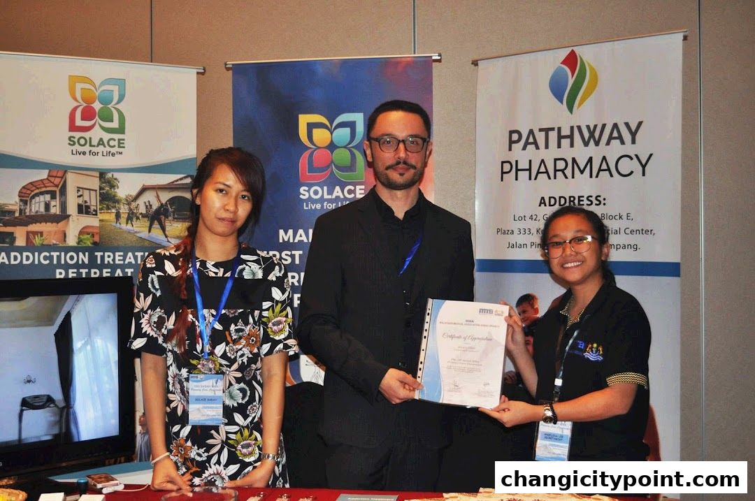Three people stand behind a table with banners for Solace Asia and Pathway Pharmacy.