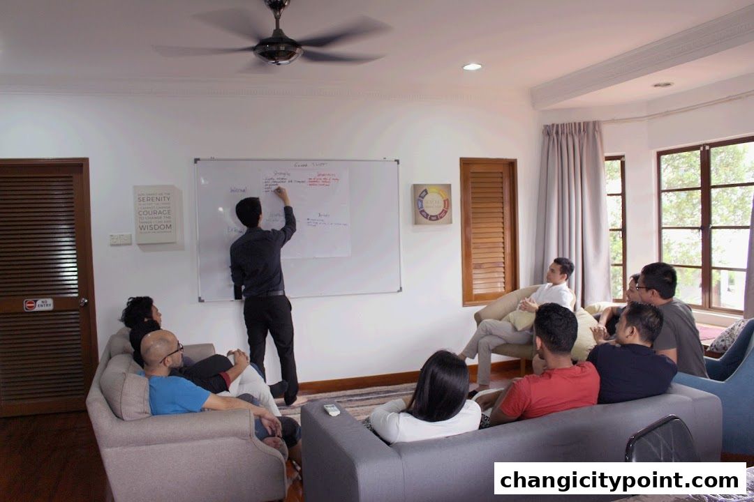A group of people attend a presentation in a modern office setting with a whiteboard.