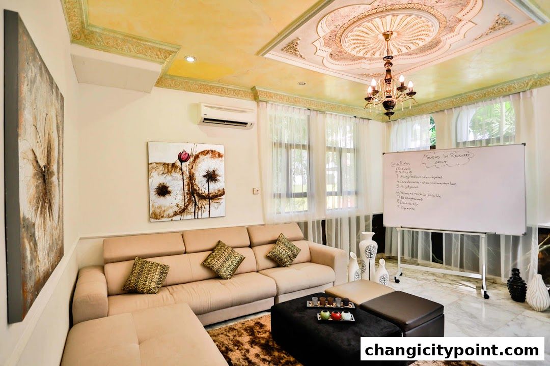 A comfortable lounge area with a sofa, artwork, and a whiteboard with group rules.