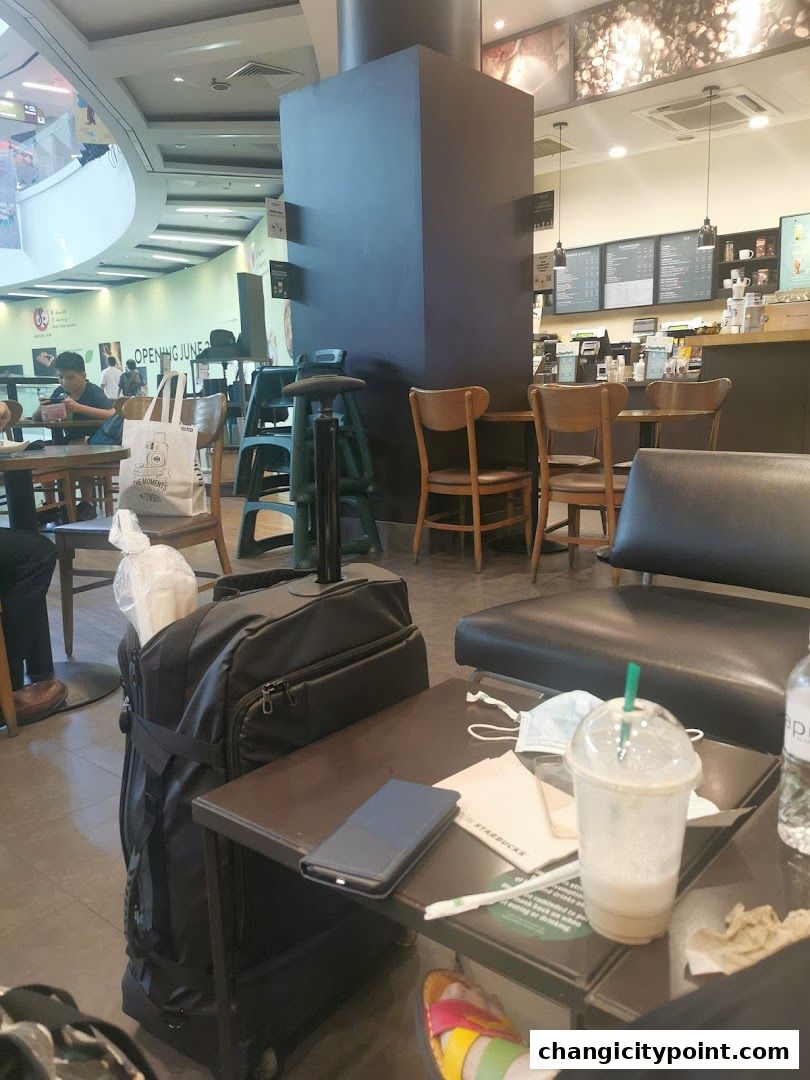 Interior of a Starbucks with seating, a counter, and a drink on a table.